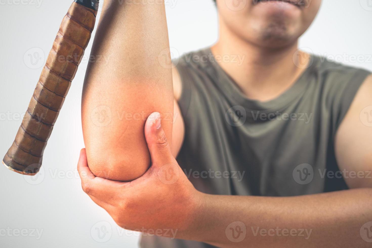 concetto di infortunio al gomito del tennista. l'uomo tiene la racchetta. l'area dei sintomi è mostrata con il colore rosso. conoscenza sanitaria. primo piano medio. foto