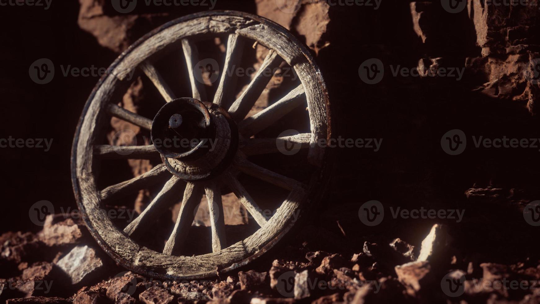 vecchia ruota del carrello in legno su rocce di pietra foto