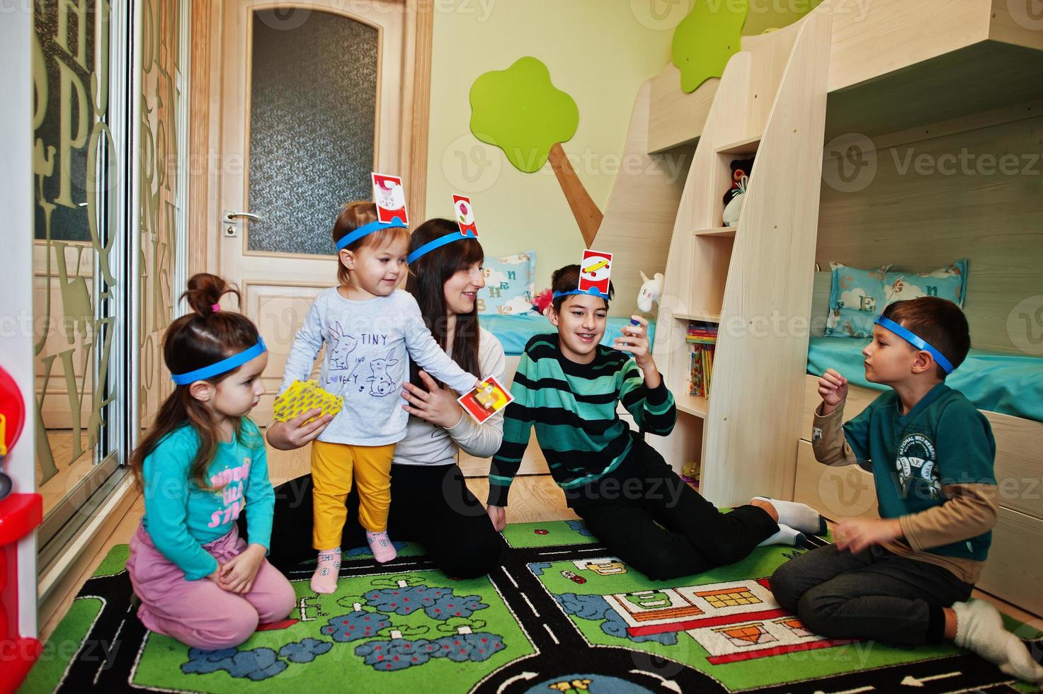 famiglia felice con quattro bambini che giocano a indovinare chi divertendosi a casa. foto