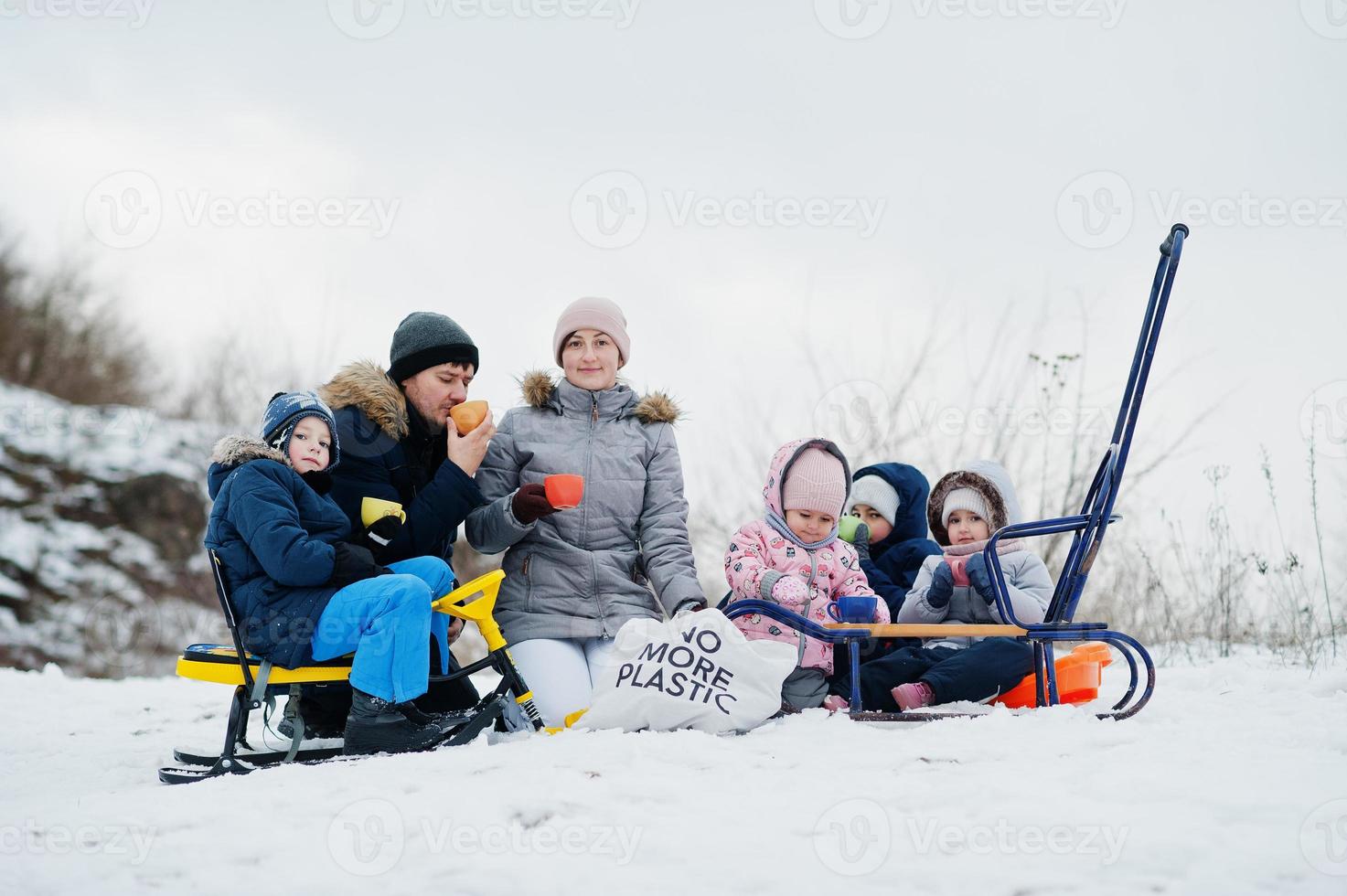 giochi in famiglia e gite in slitta in inverno all'aperto, i bambini si divertono, bevono tè. foto