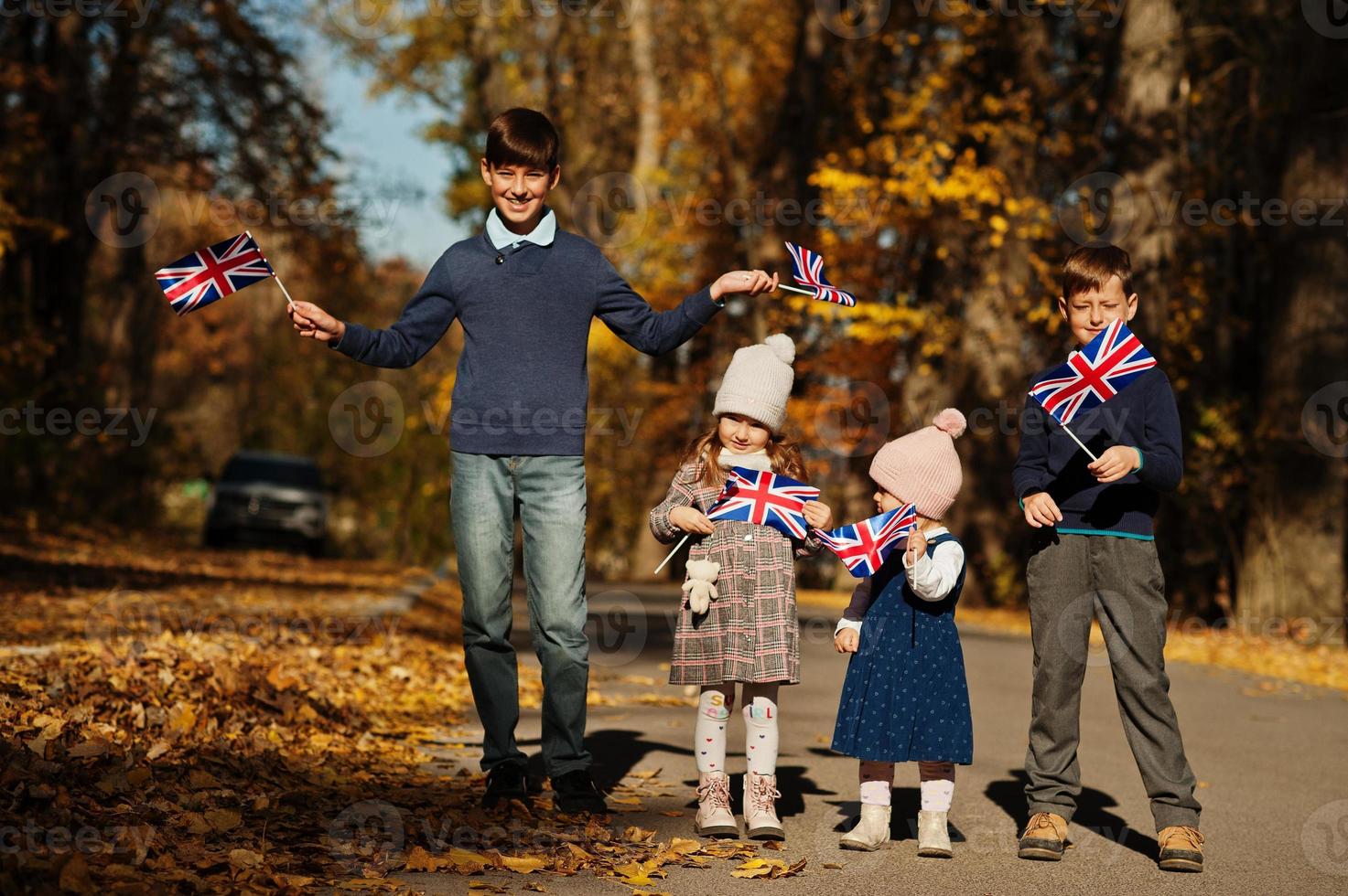 festa nazionale del regno unito. quattro bambini con bandiere britanniche nel parco autunnale. Britishness che celebra il Regno Unito. foto