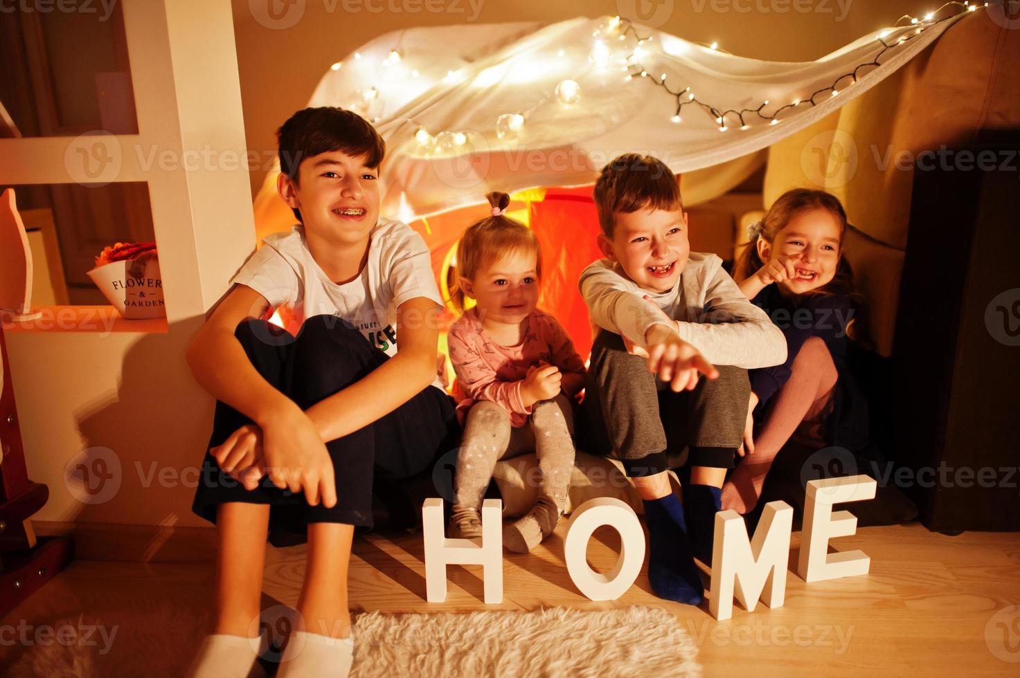 bambini in tenda che guardano la tv di notte a casa. umore hygge. foto