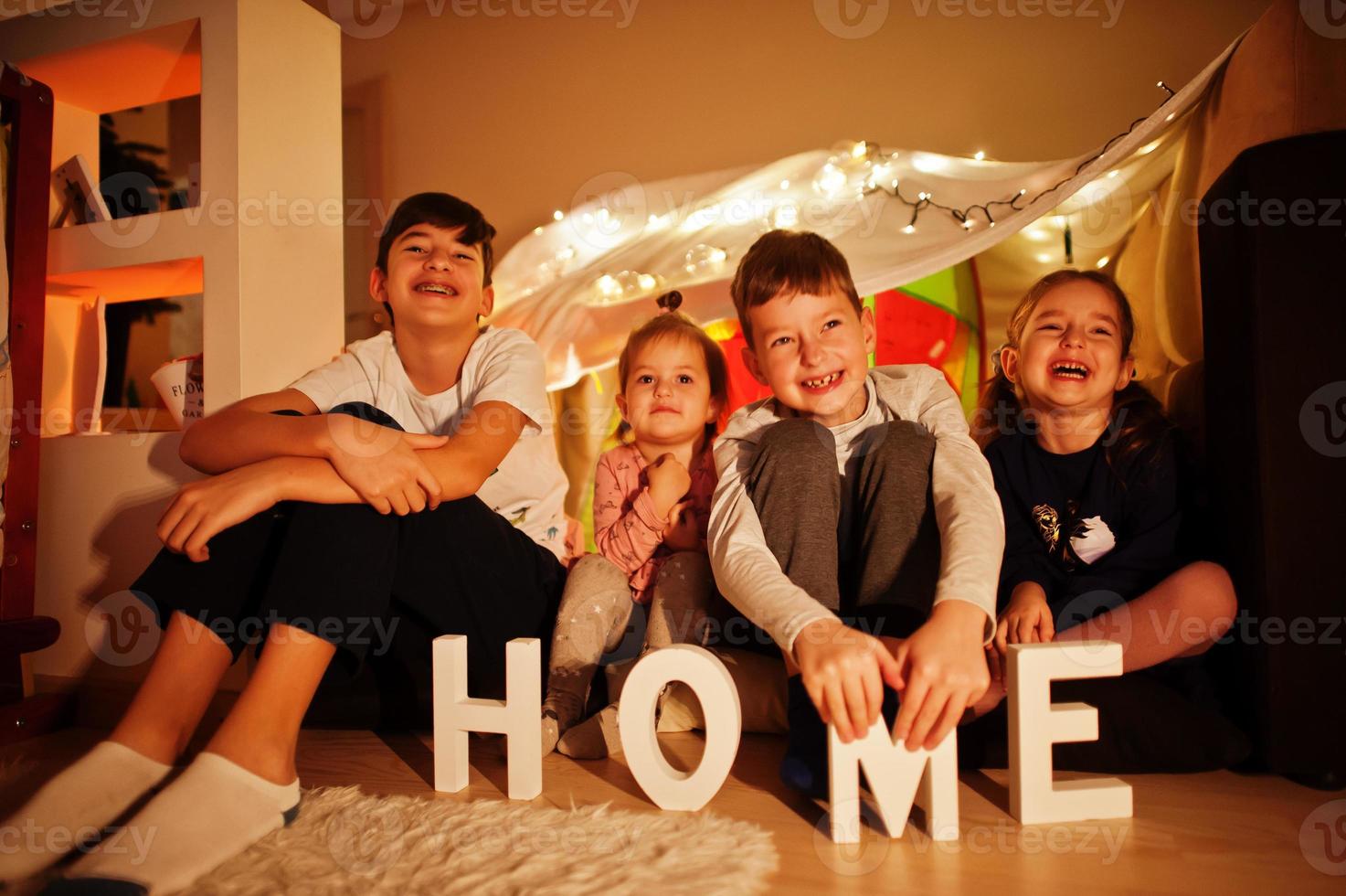 bambini in tenda che guardano la tv di notte a casa. umore hygge. foto