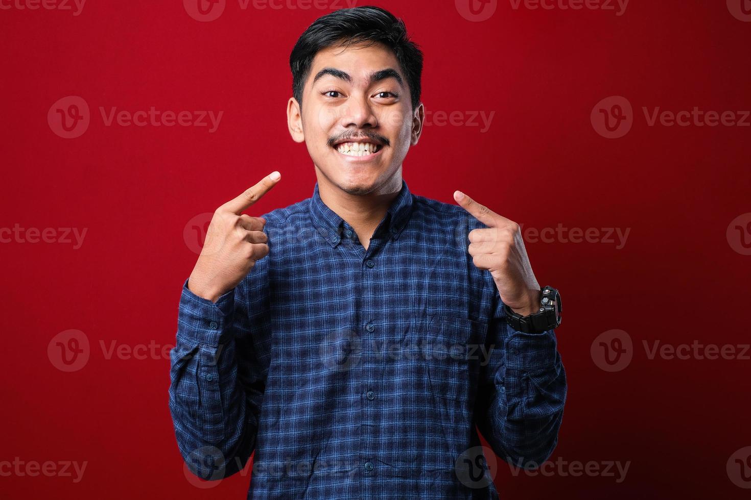 giovane bell'uomo che indossa un maglione casual sorridente allegro che mostra e indica con le dita i denti e la bocca. concetto di salute dentale. foto
