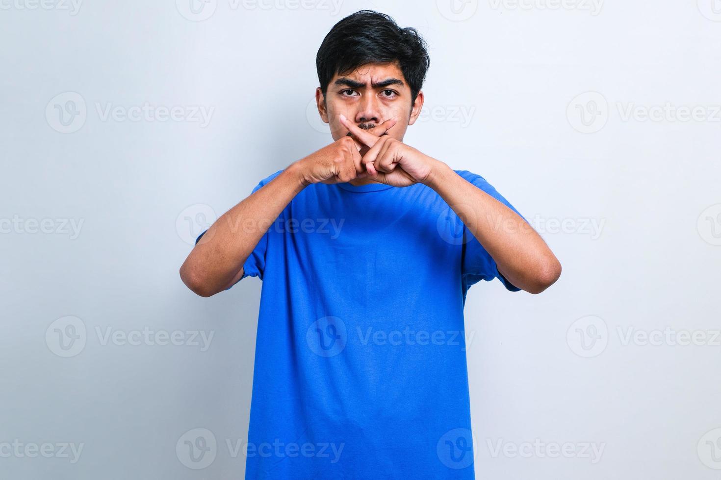 giovane uomo asiatico che fa espressione di rifiuto incrociando le dita facendo segno negativo foto