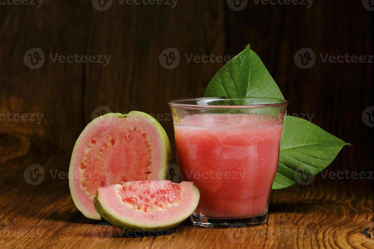 il succo di guava viene servito su uno sfondo di legno foto