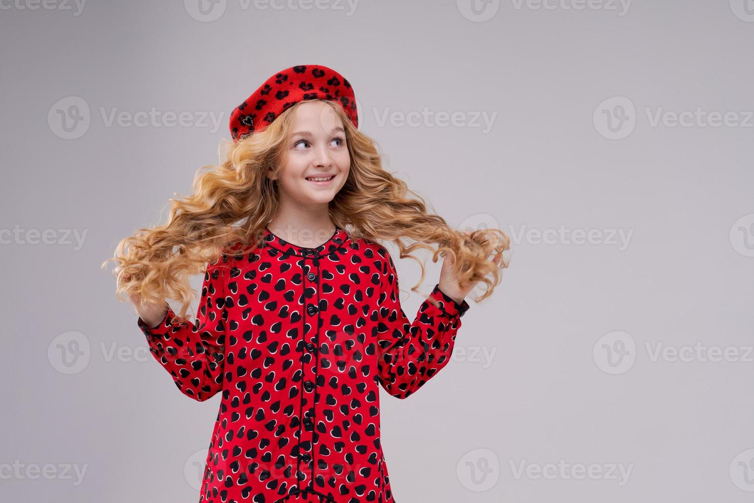 icona della moda francese. bambino felice che indossa un berretto rosso francese e si veste su una luce foto