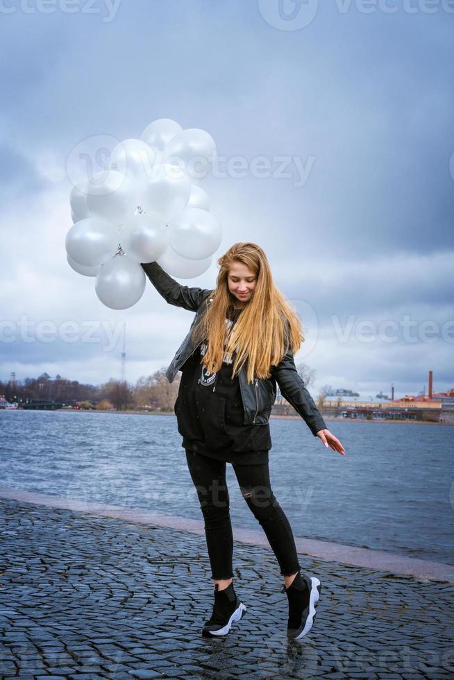ragazza felice che gioca con i palloncini all'aperto saltando di felicità foto