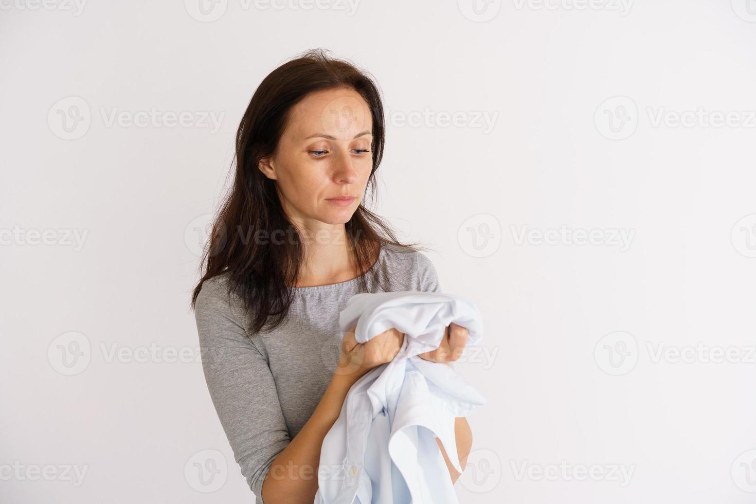 donna che tiene camicia profumata bianca pulita foto