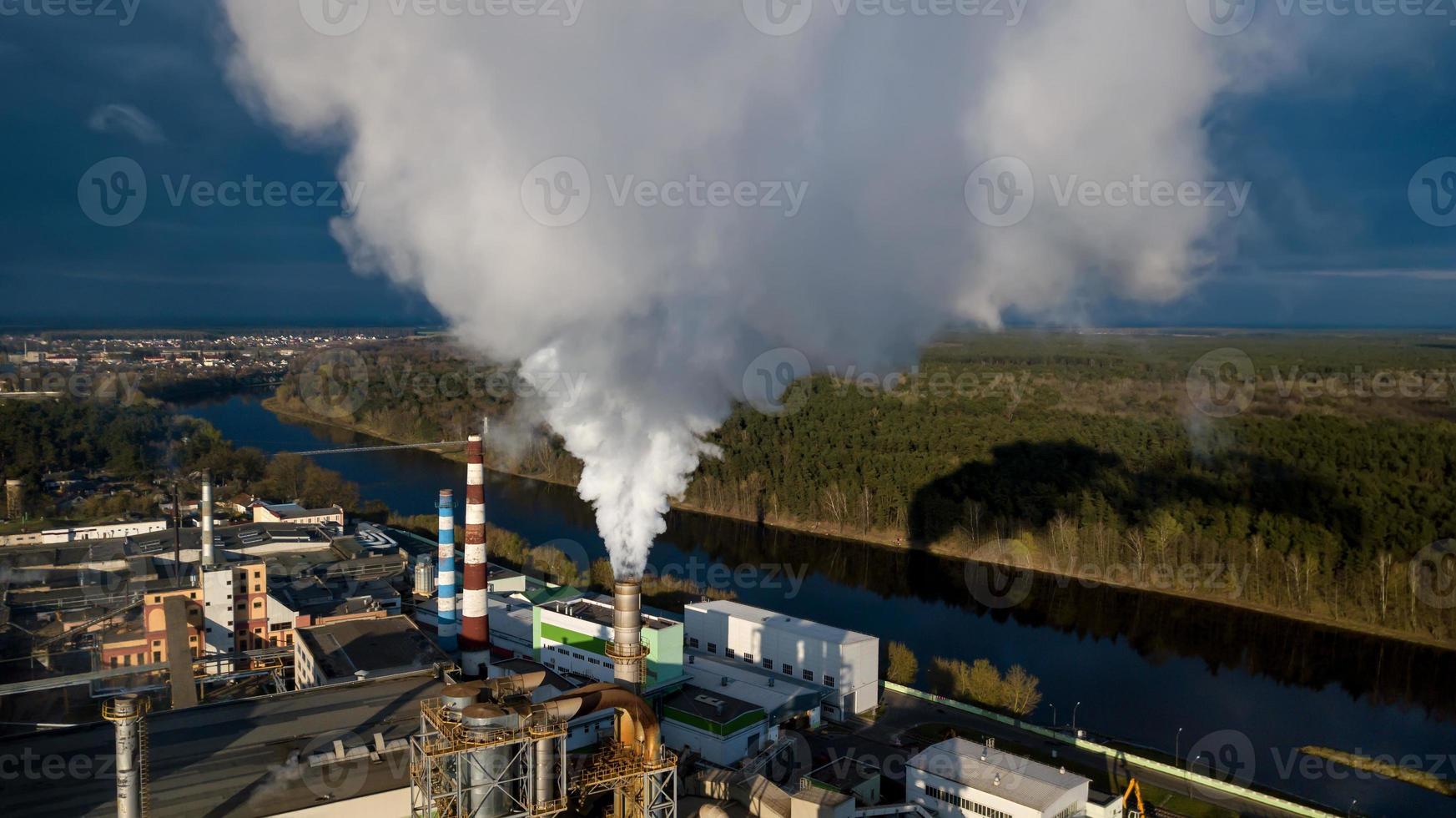 tubi con fumo in un edificio di fabbrica. concetto di inquinamento ambientale foto