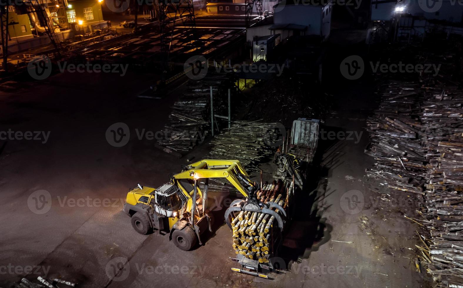 fabbrica di lavorazione del legno. caricare la foresta nel camion. fotografia aerea notturna foto