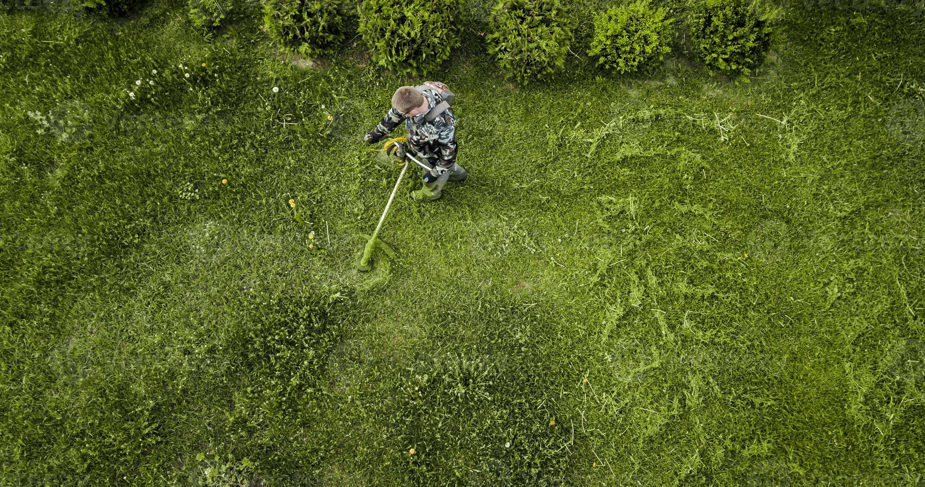 l'uomo del tosaerba falcia il prato la vista dall'alto foto