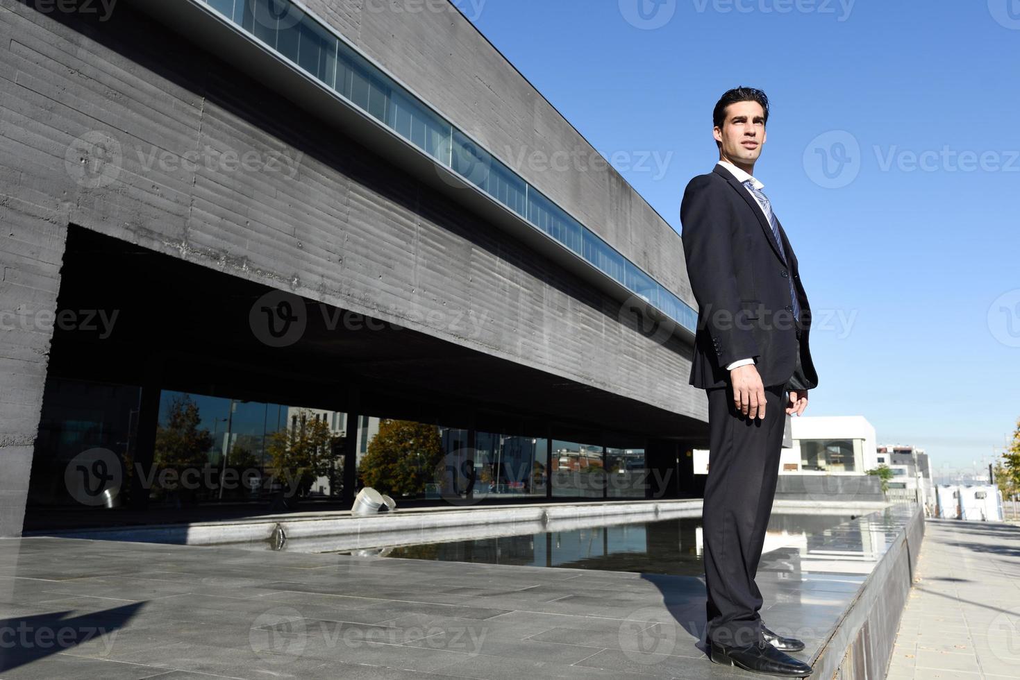 giovane uomo d'affari che indossa abito blu e cravatta in background urbano foto