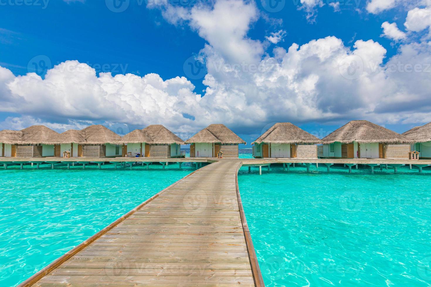 bungalow sull'acqua nell'Oceano Indiano, isole maldive. laguna tropicale dell'oceano, acqua turchese, cielo nuvoloso idilliaco. vacanze estive, vacanze, destinazione di viaggio foto