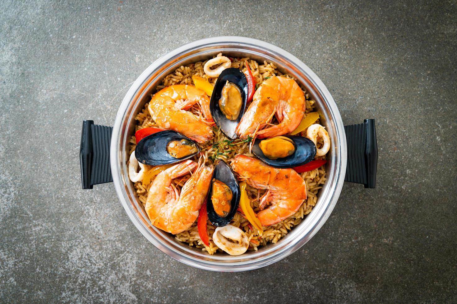 paella di mare con gamberi, vongole, cozze su riso allo zafferano foto