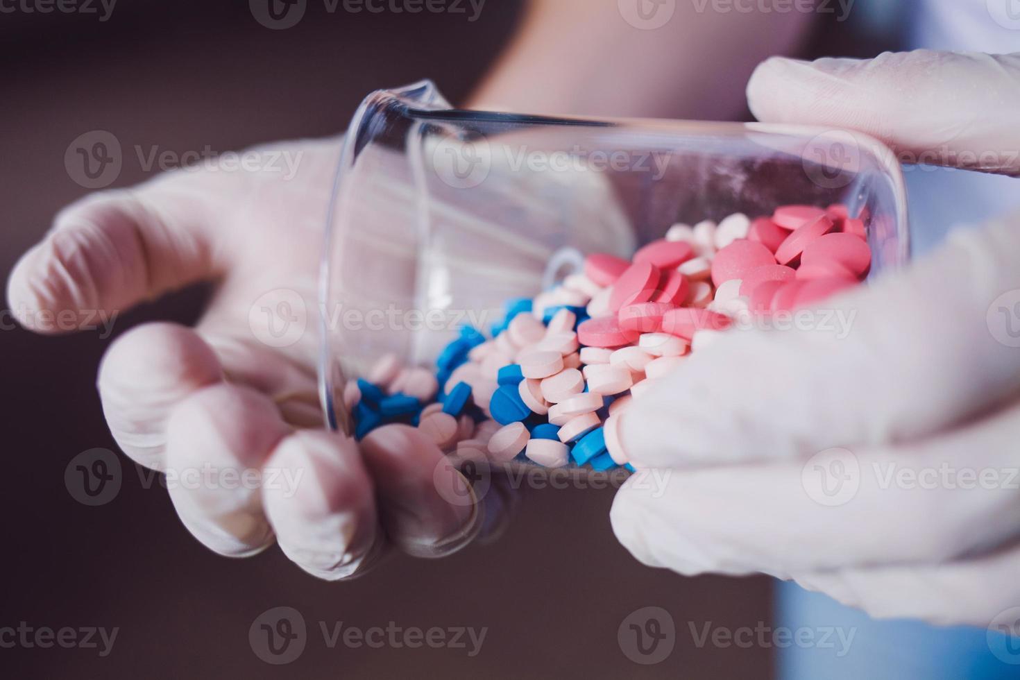 il medico tiene in mano una bottiglia di pillole foto