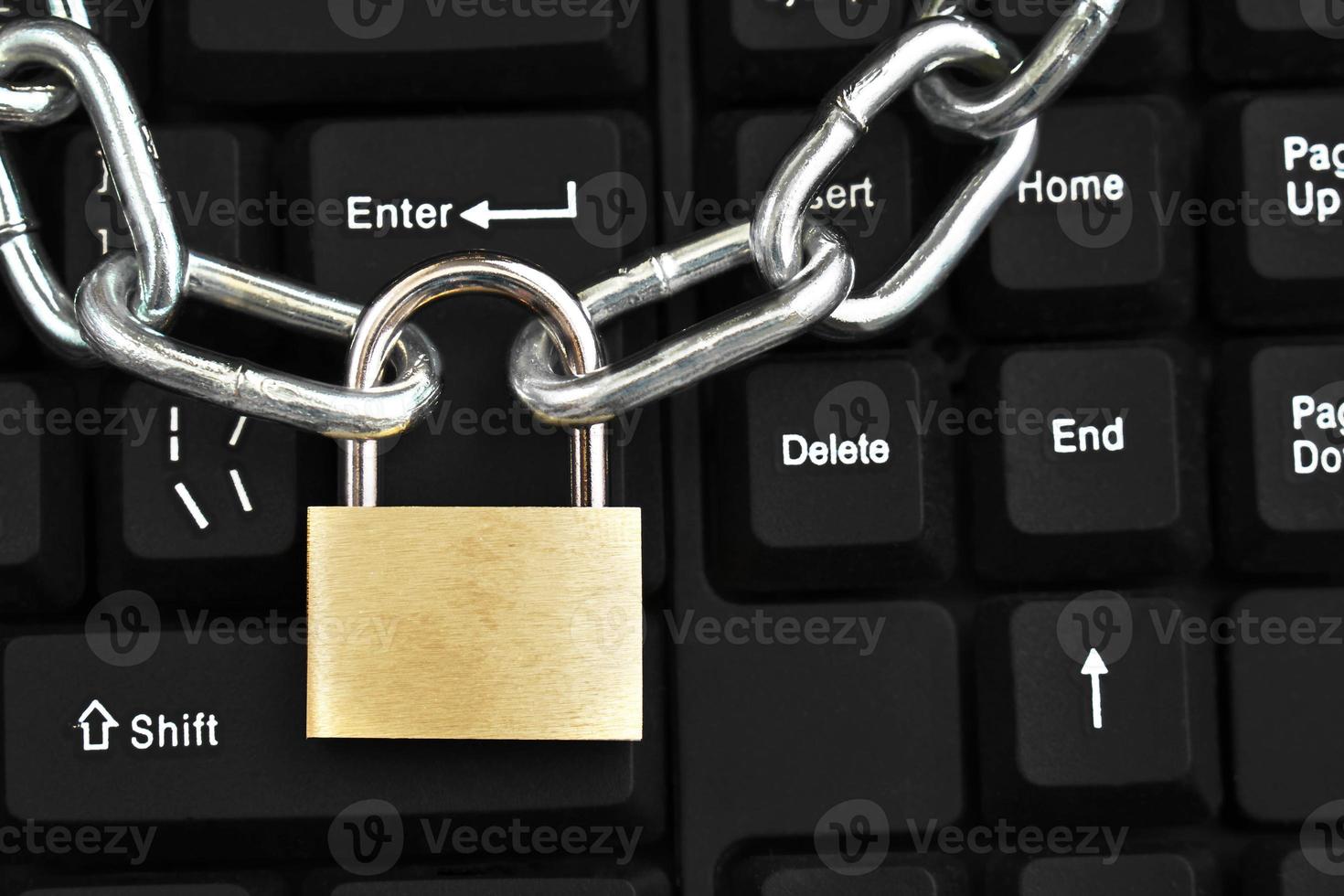 catena metallica con un lucchetto bloccato sulla tastiera di un computer. foto