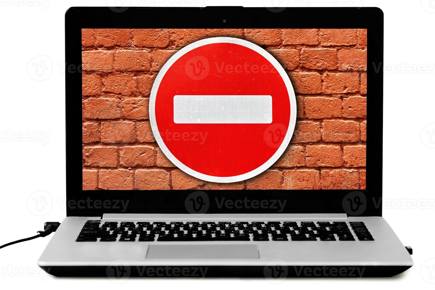 laptop con il cartello stradale non entrare e un muro di mattoni rossi sullo schermo foto