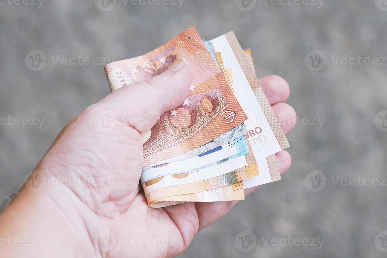 mano che tiene un pugno di banconote in euro foto