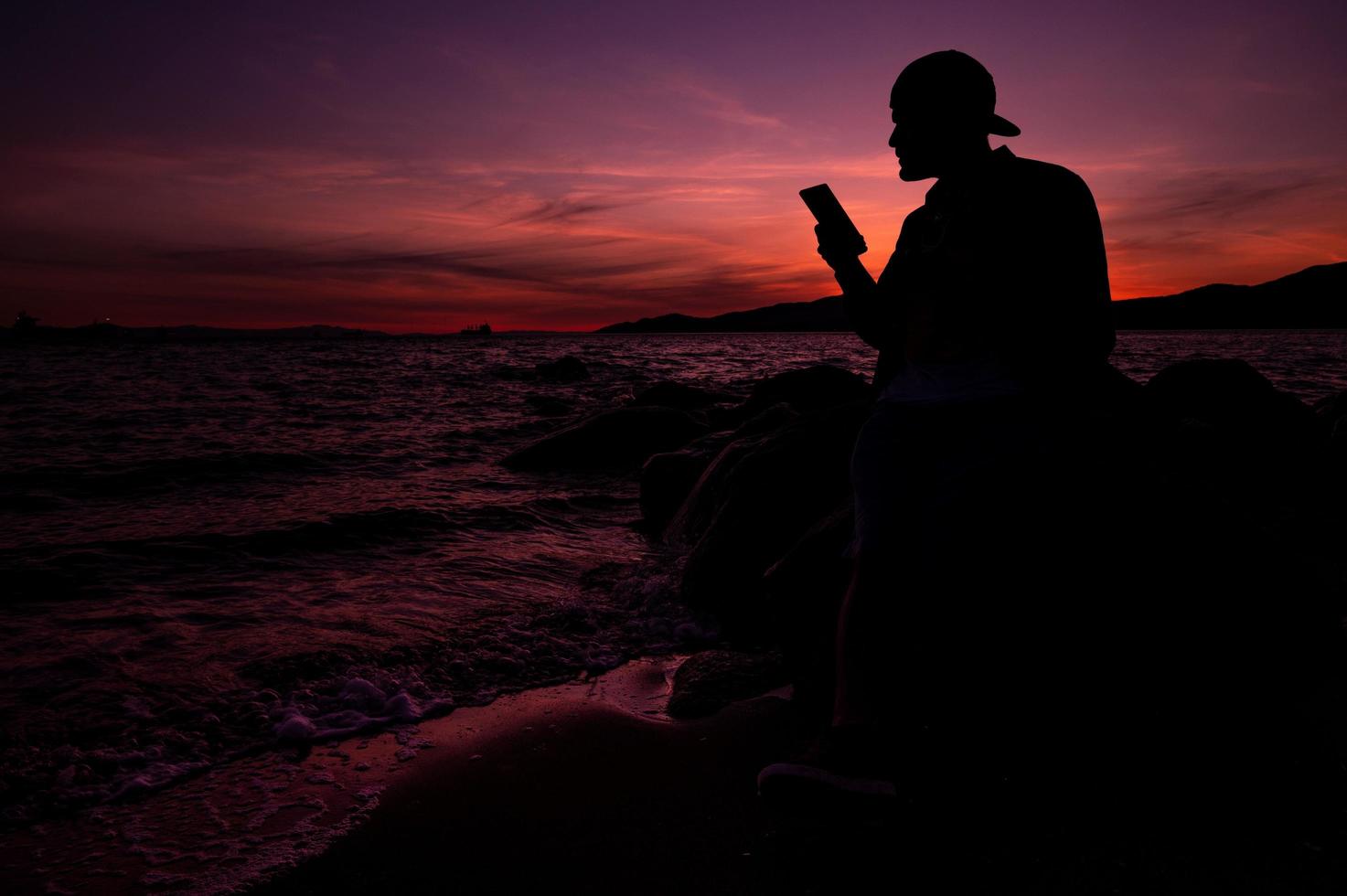 sagoma di un uomo durante un tramonto rosa sulla spiaggia foto