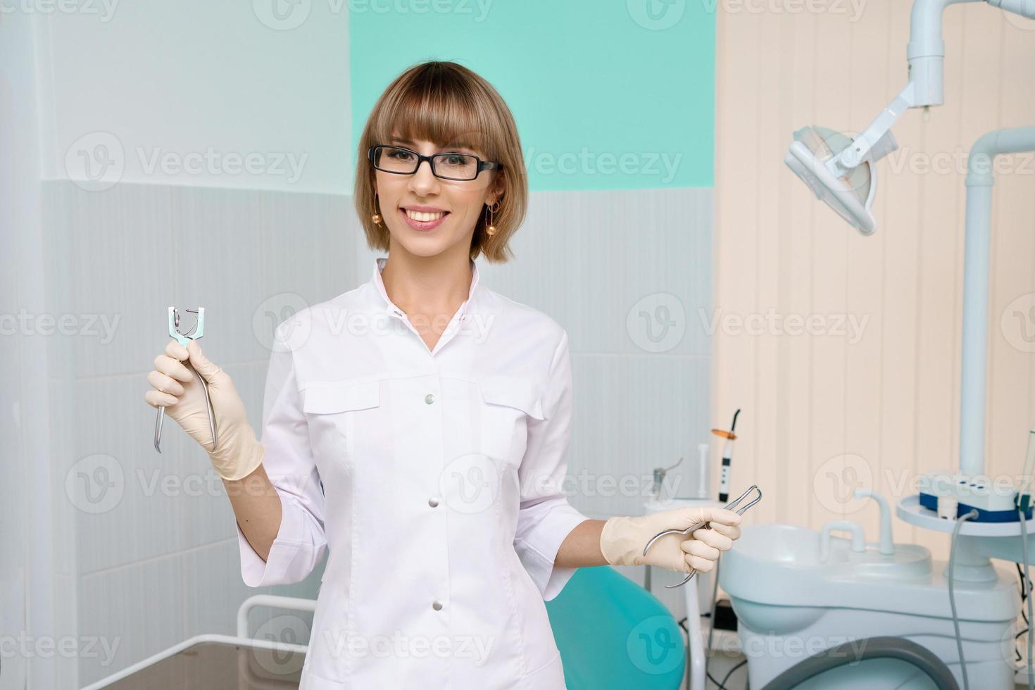 dentista con strumenti in mano nello studio dentistico foto