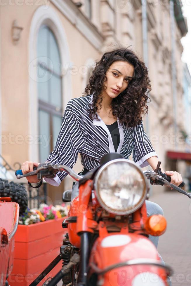 giovane bella donna sulla guida della moto foto