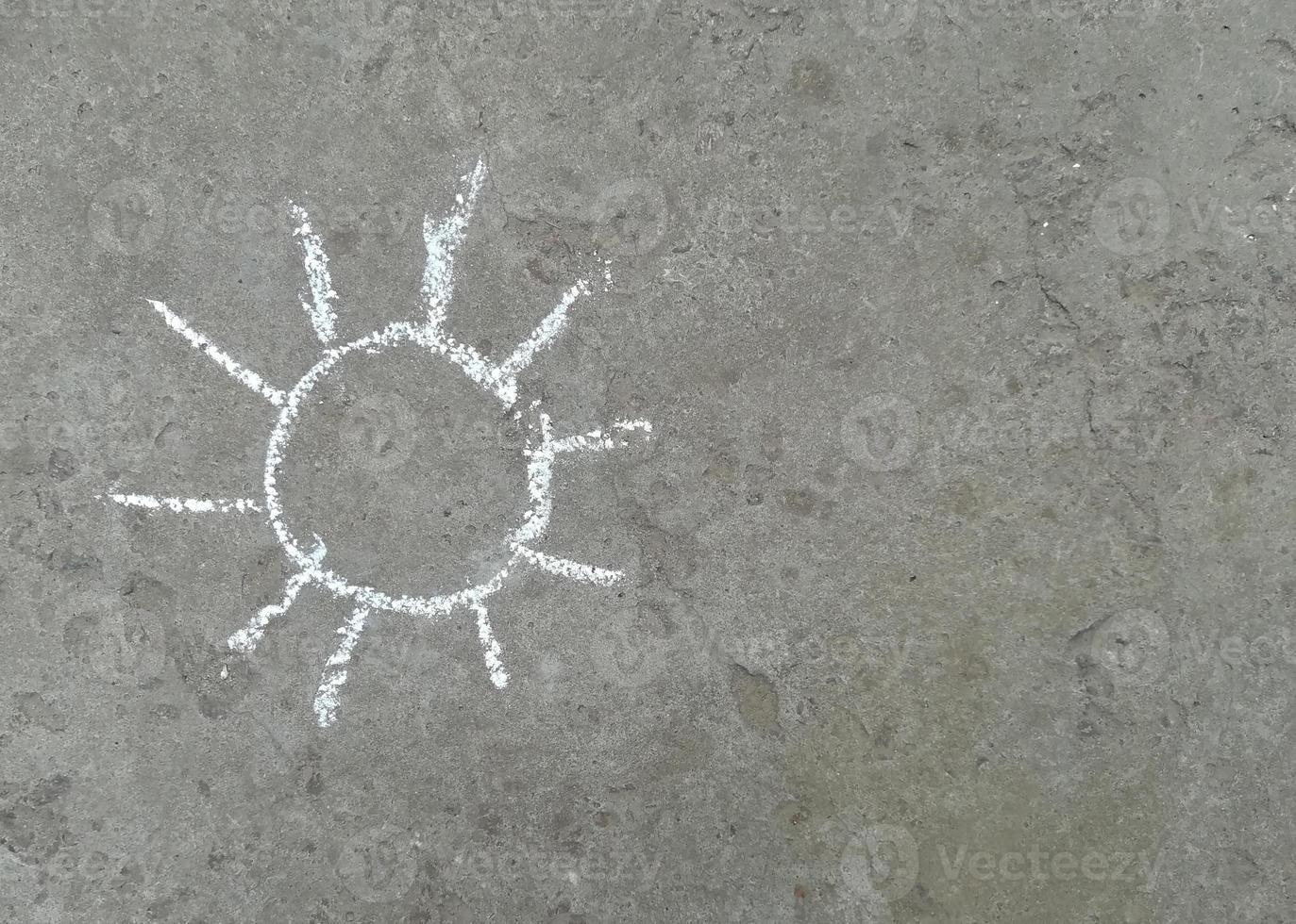 il sole è disegnato con il gesso sull'asfalto. estate. posto banner per testo, creatività per bambini foto
