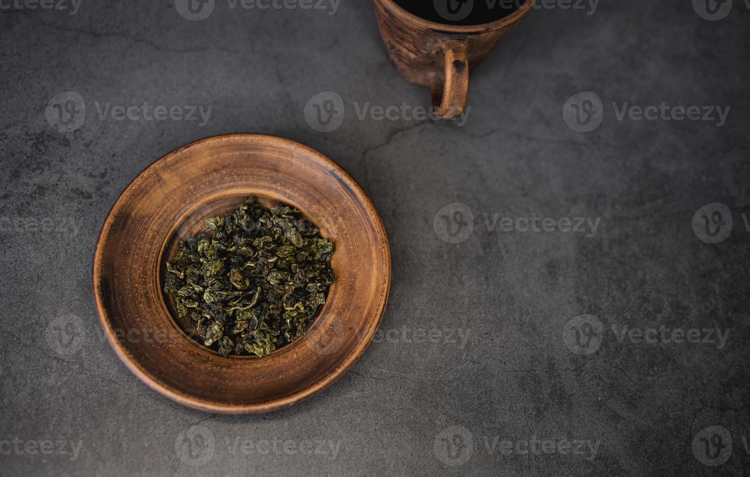 foglie di tè su una ciotola di argilla foto