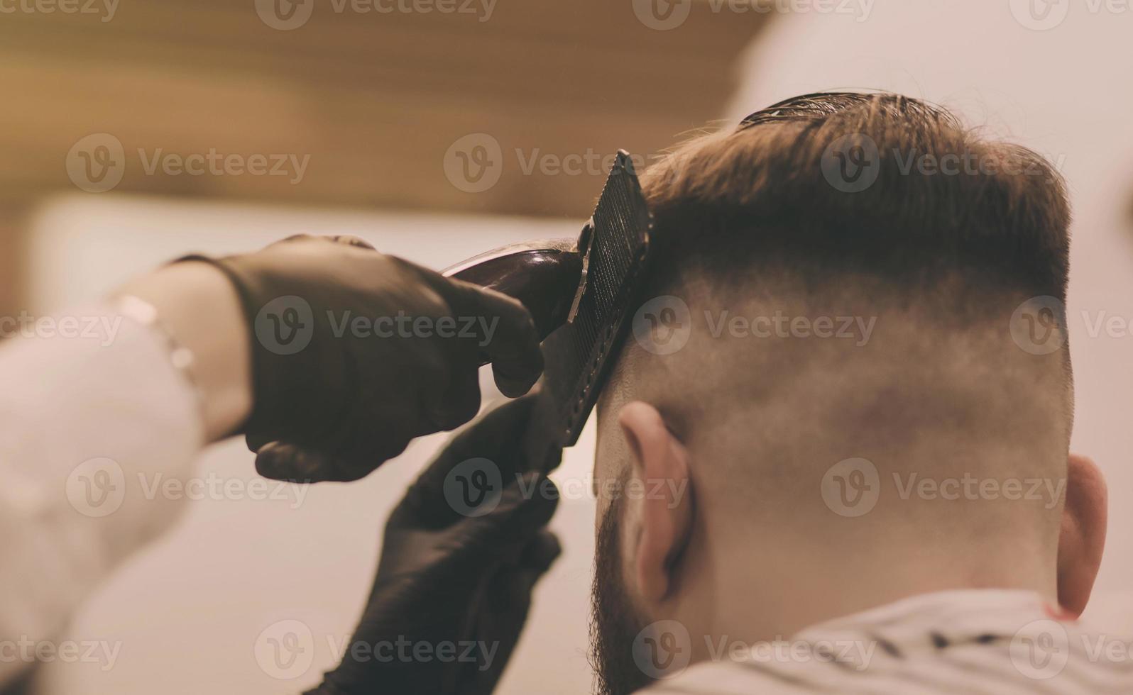 bell'uomo con la barba nel negozio di barbiere foto