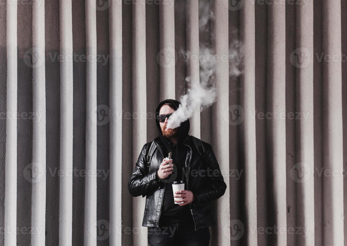 uomo barbuto con sigaretta elettronica foto