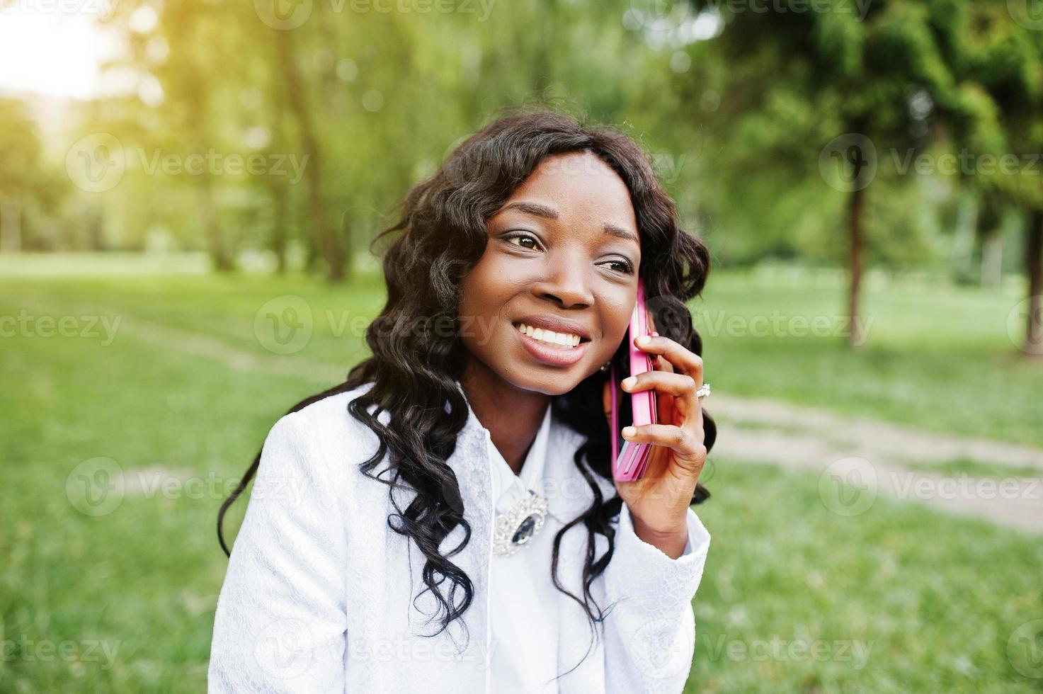 primo piano ritratto di elegante ragazza afroamericana nera con telefono cellulare rosa foto