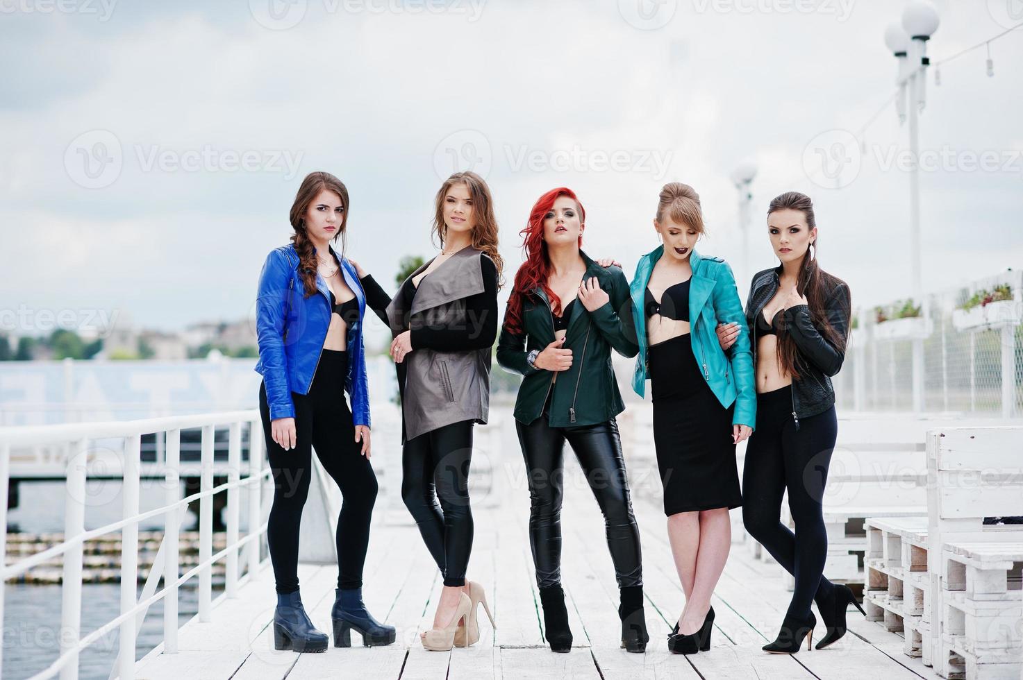 gruppo di ragazze modelle sexy in reggiseno nero e giacche di pelle sul molo foto