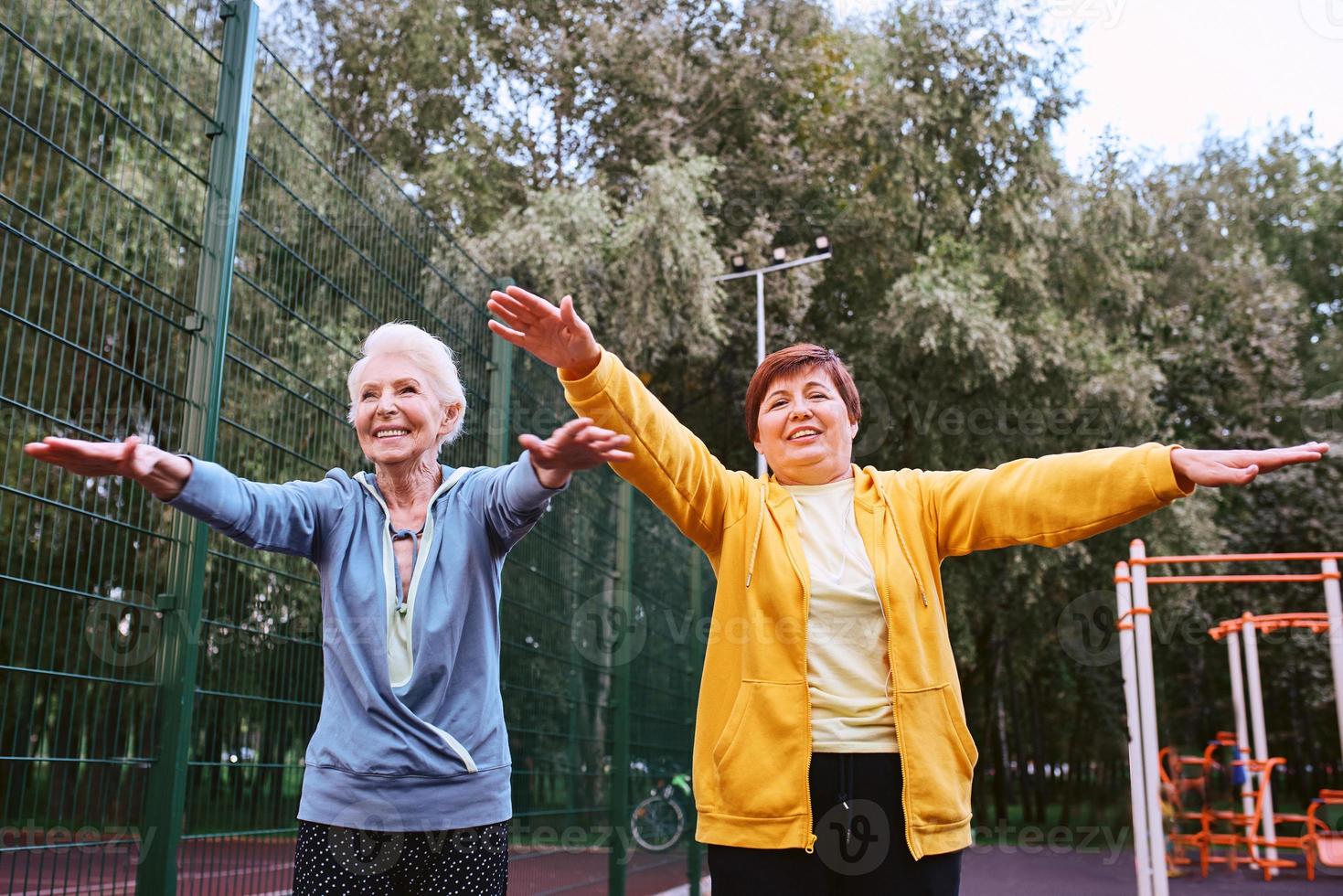 due donne mature che fanno esercizi sportivi nel parco. concetto di stile di vita sano foto