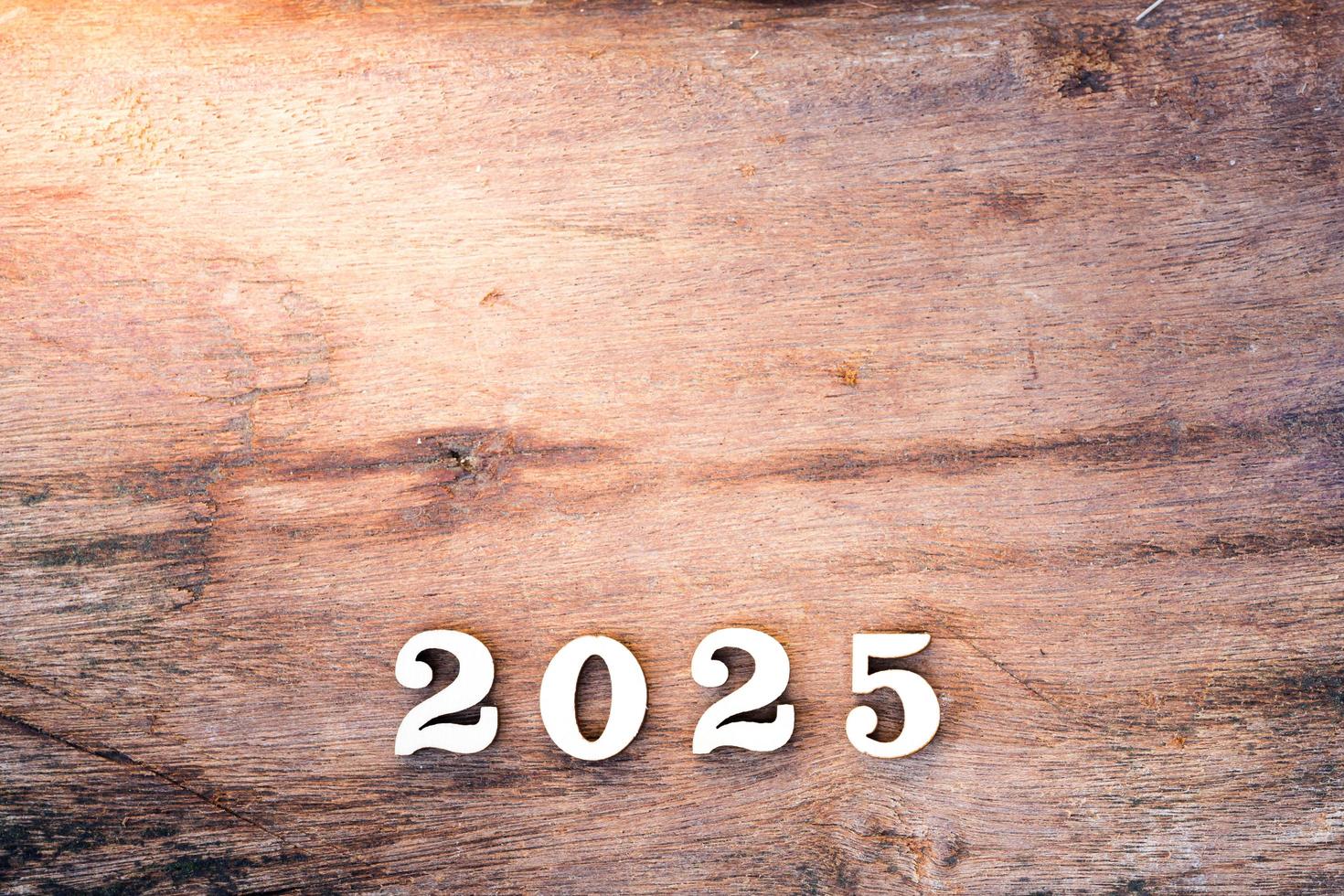 testo di legno 2025 su fondo di legno del foglio. spazio vuoto. concetto di felice anno nuovo. foto