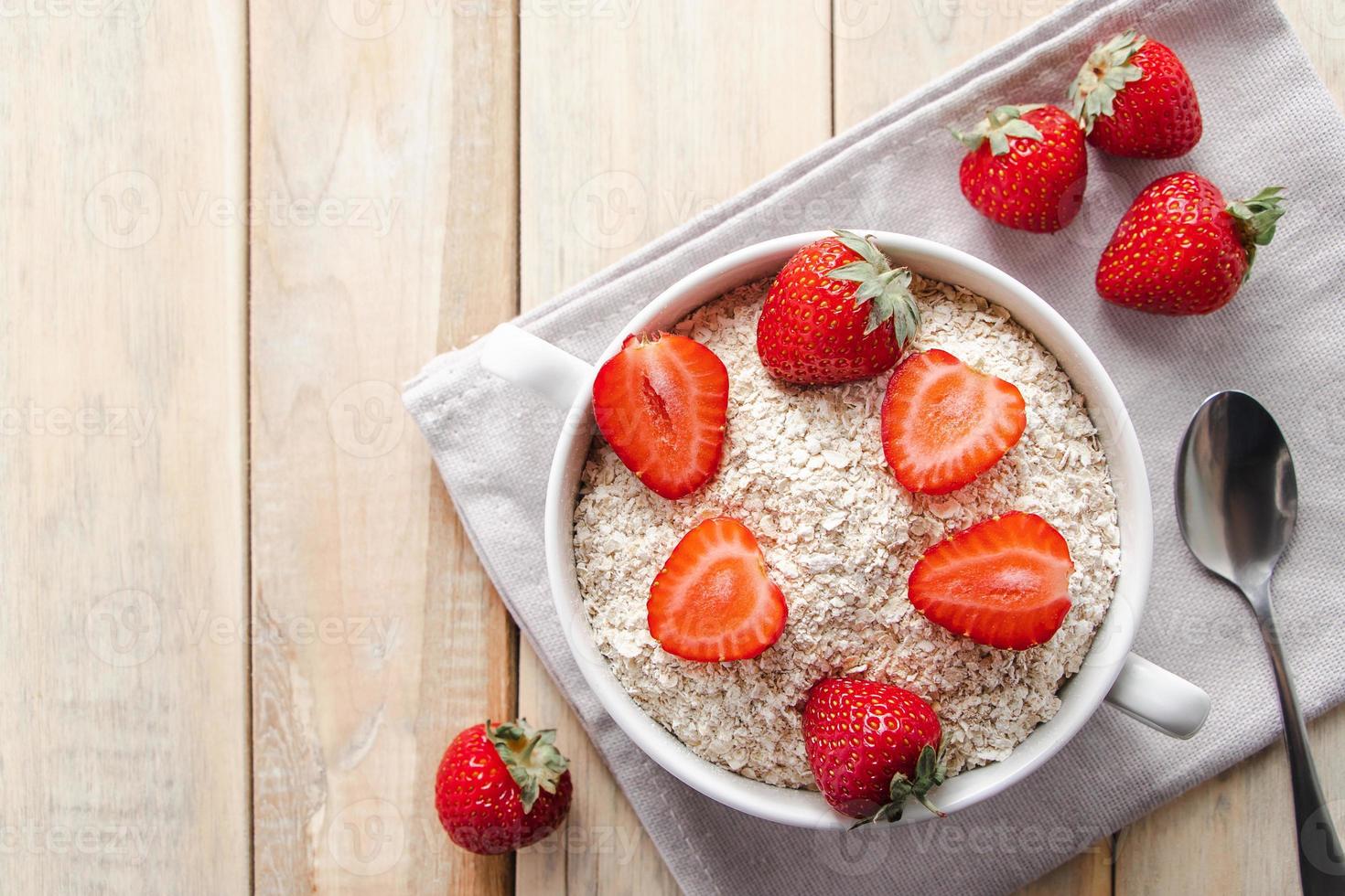 muesli di avena e fragole fresche su fondo di legno. foto