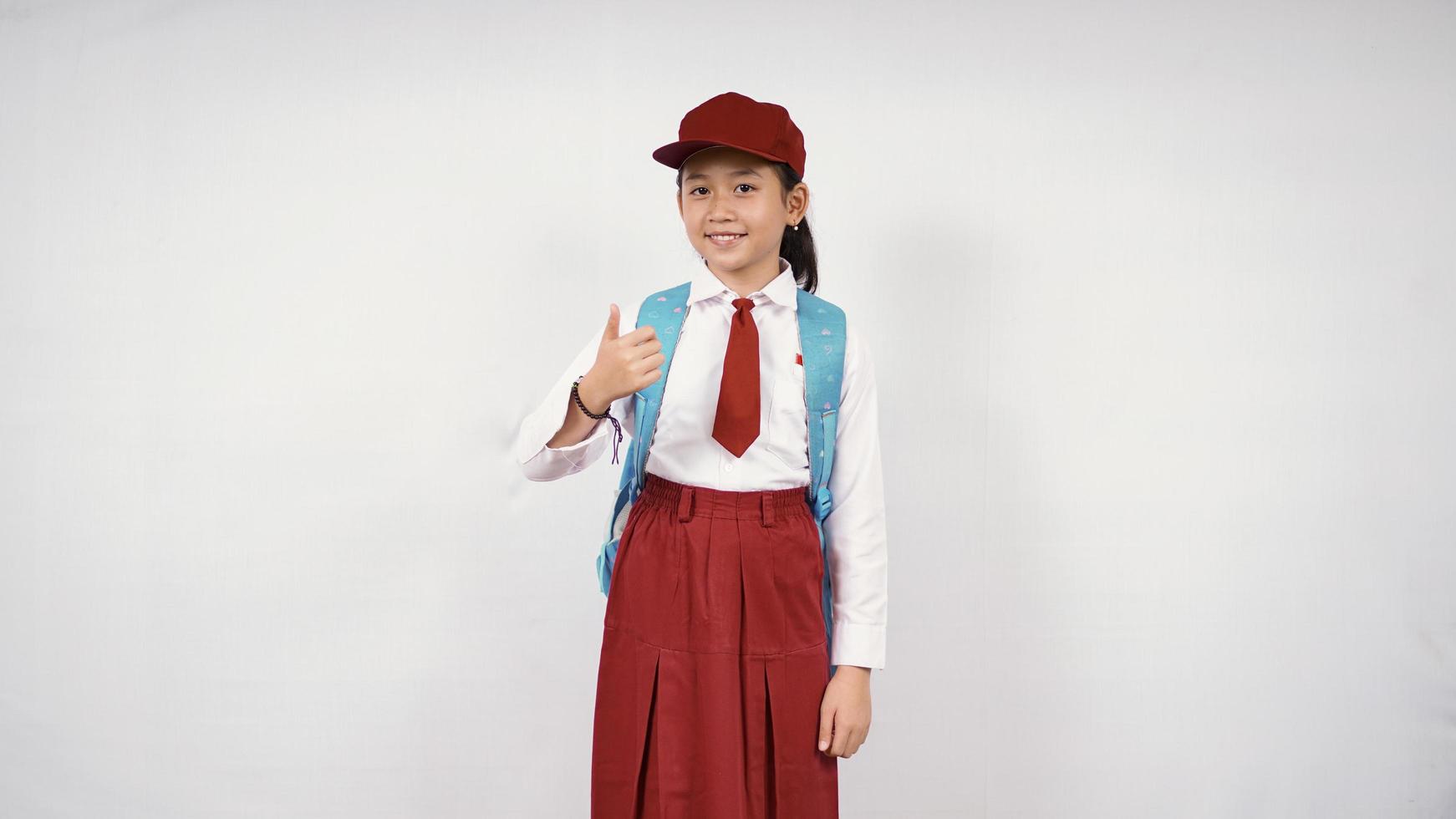 ragazza asiatica della scuola elementare pronta per andare isolata su fondo bianco foto
