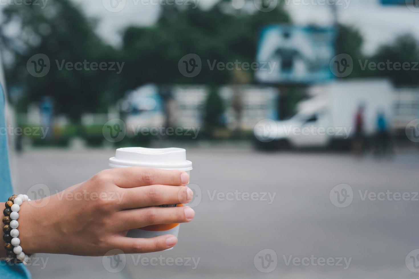 mano che tiene una tazza di plastica di caffè caldo con spazio per la copia. porta il caffè a casa in un nuovo concetto normale. foto