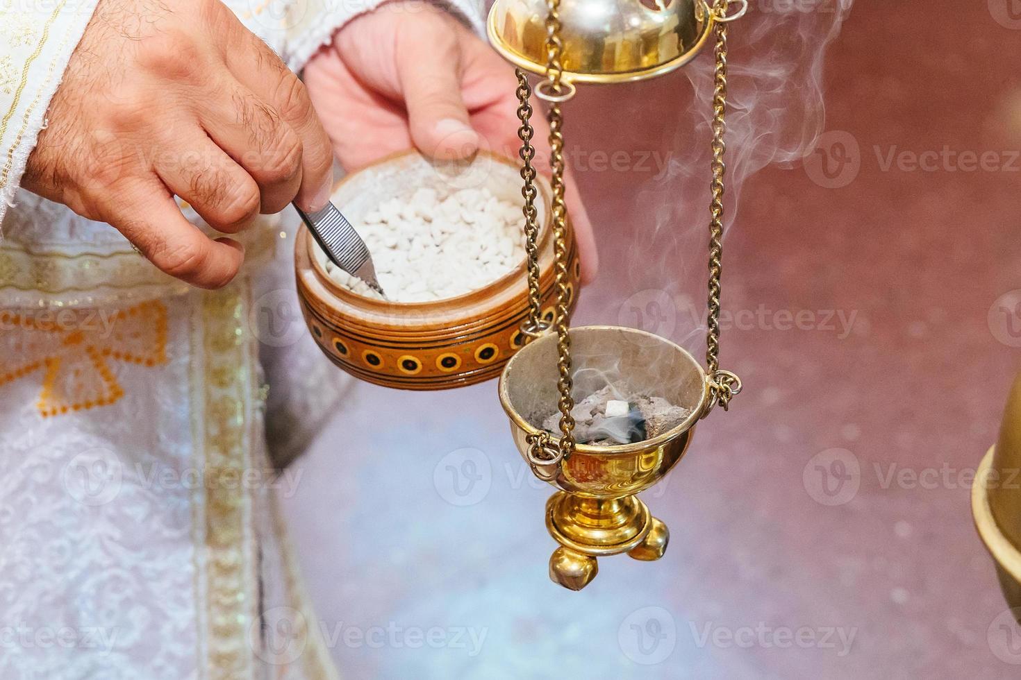 sacerdote che canta in un sermone cristiano incensiere rito della chiesa foog foto