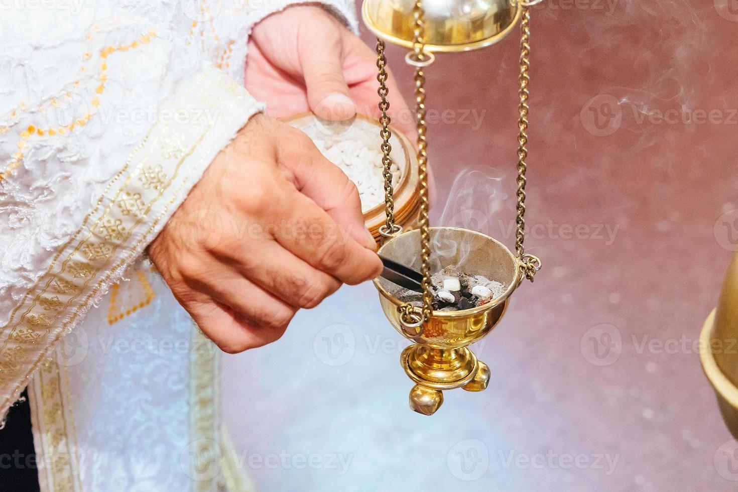 sacerdote che canta in un sermone cristiano incensiere rito della chiesa foog foto
