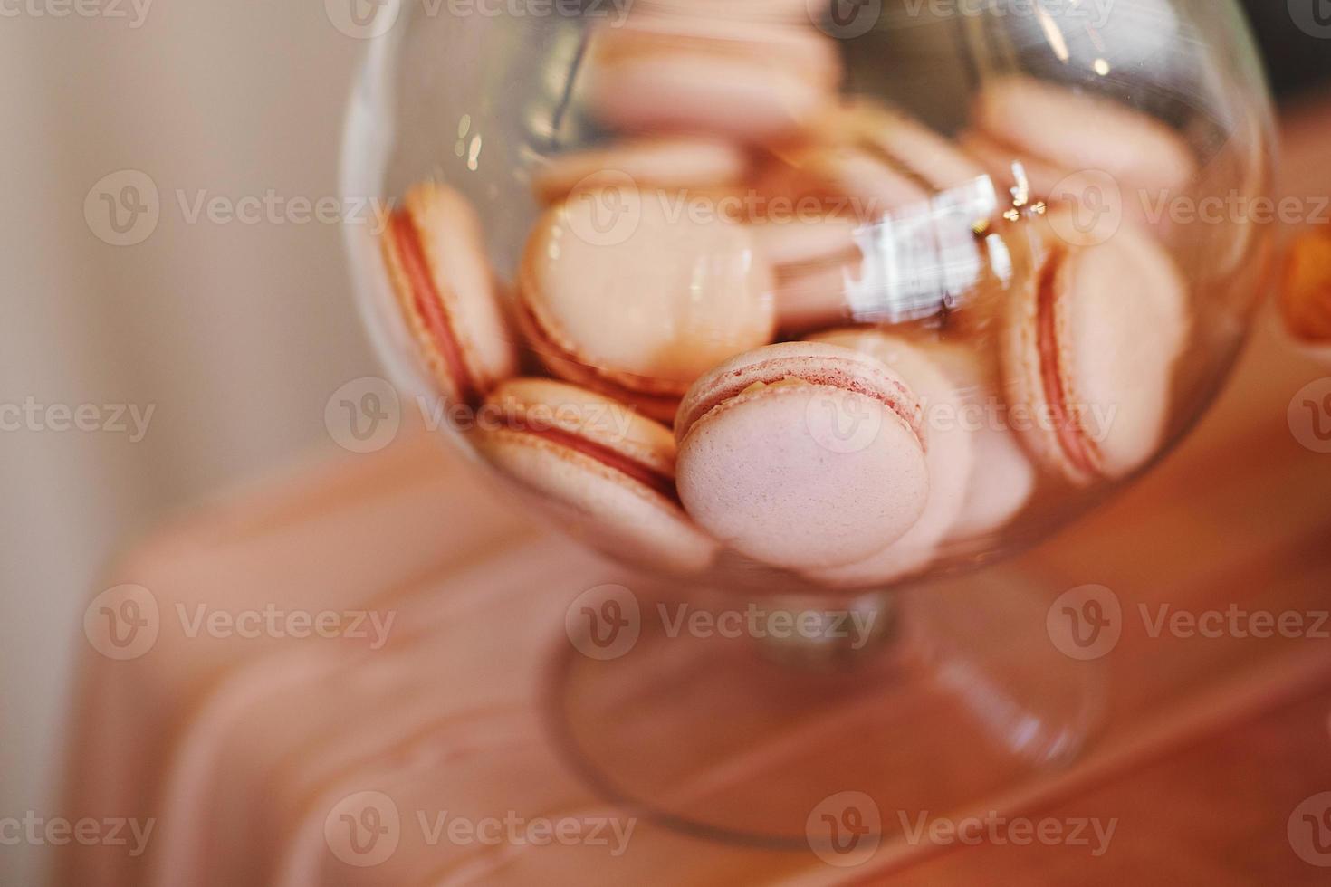 i macarons colorati stanno in un peso trasparente rotondo come parte del tavolo dolce delle caramelle. amaretti francesi. Barretta di cioccolato. foto