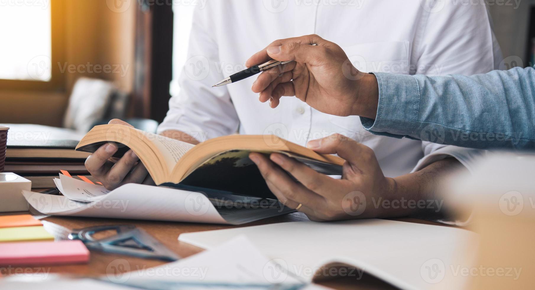 giovani studenti universitari asiatici che studiano insieme seduti alla scrivania in biblioteca. foto