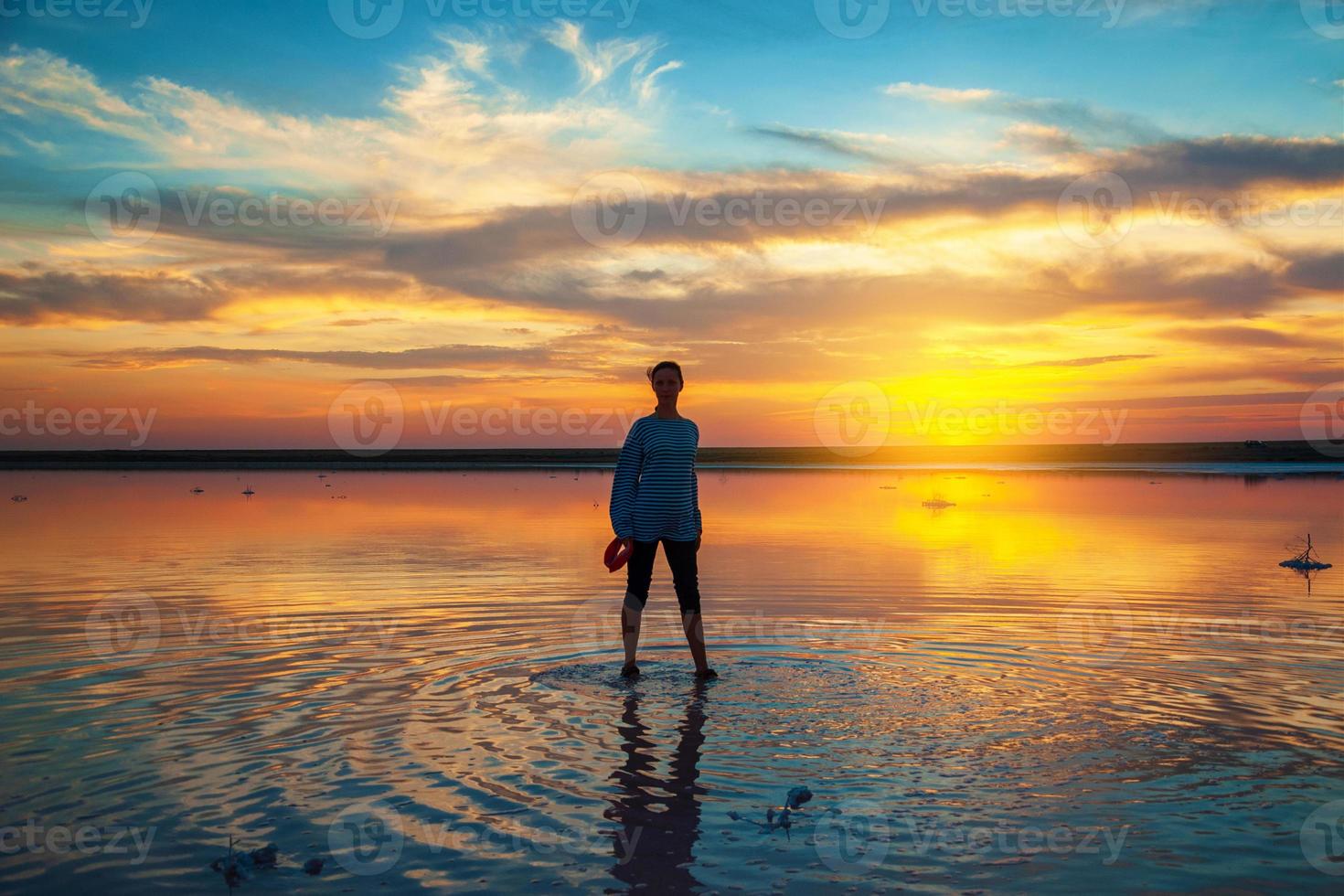 silhouette di una donna sull'acqua al tramonto, bellissimo cielo al tramonto con nuvole, concetto di turismo foto