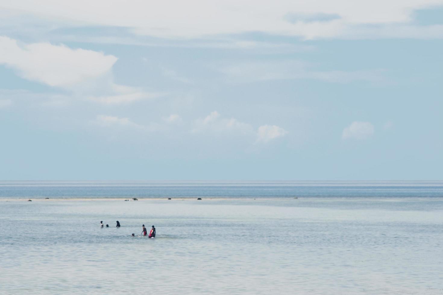 persone che nuotano sulla spiaggia ombreggiata foto