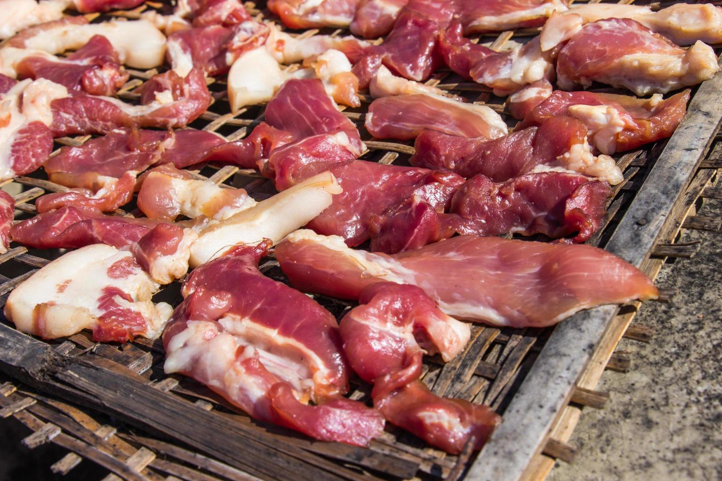 conservazione della carne di maiale a secco con palata essiccata al sole su cestini di bambù. foto