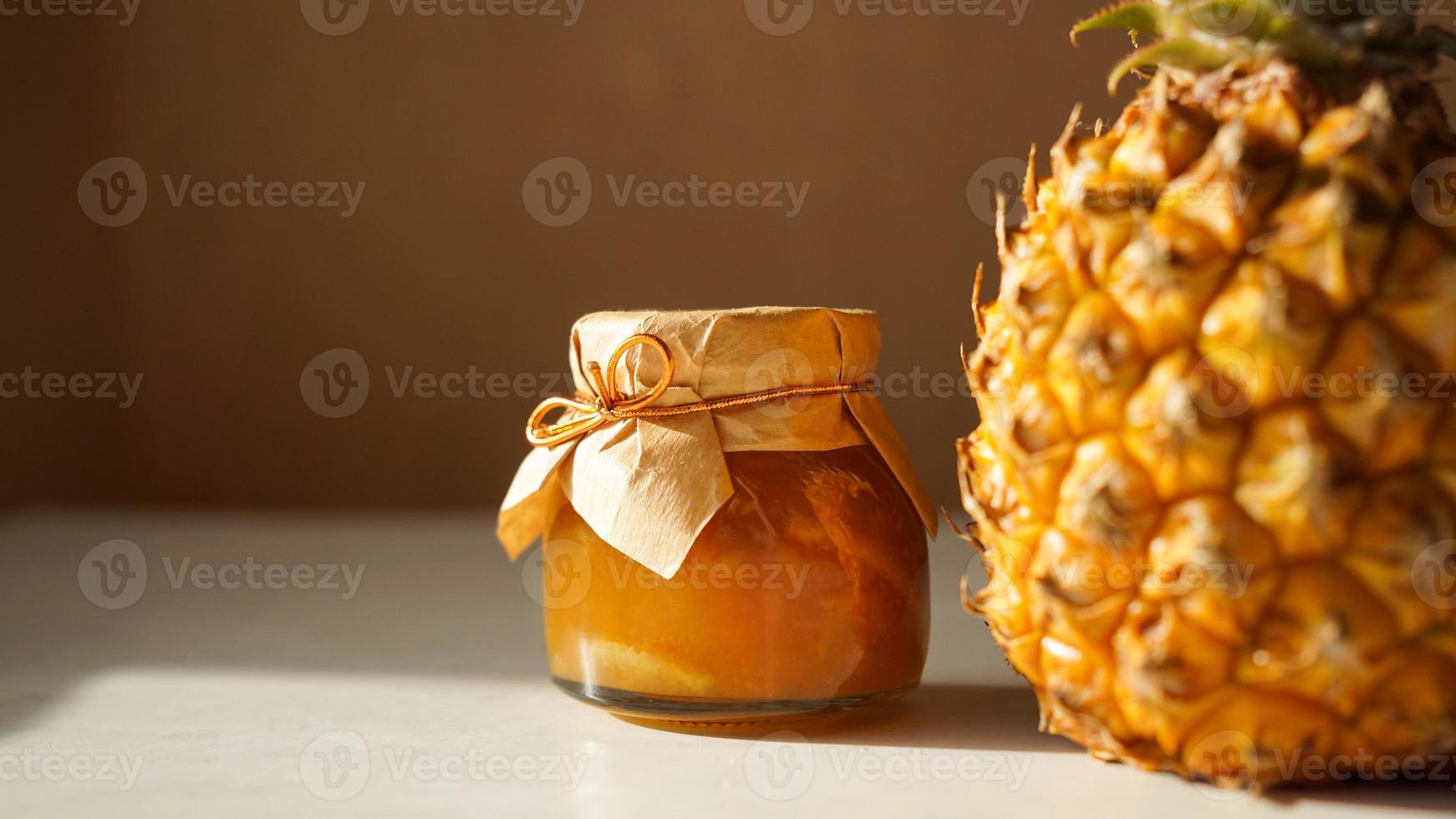 marmellata di ananas in vasetto di vetro e frutta fresca di ananas con ombre dure foto