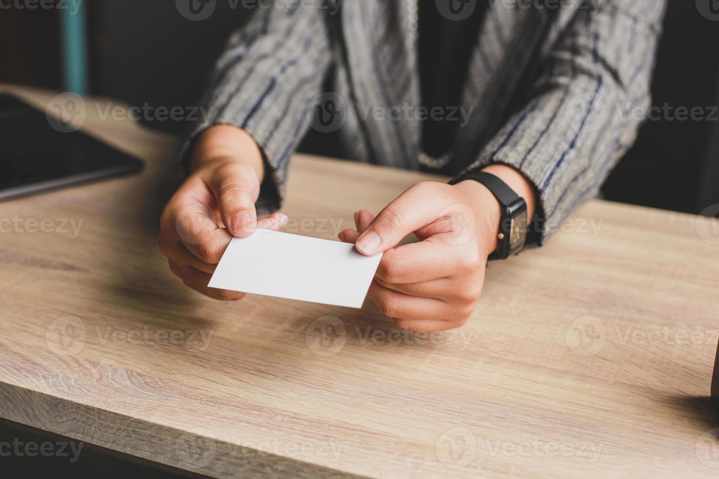 donna d'affari che tiene e dà il biglietto da visita bianco o il nome della carta in bianco nelle mani. modello per il tuo design. biglietto da visita mock up foto