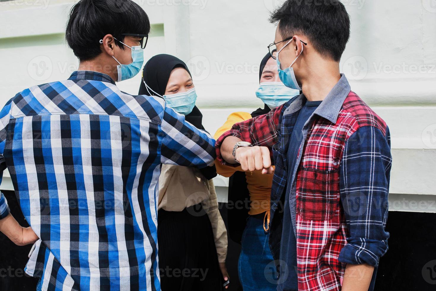 i giovani si salutano con il gomito. nuova normalità della stretta di mano coronavirus o concetto covid-19. foto