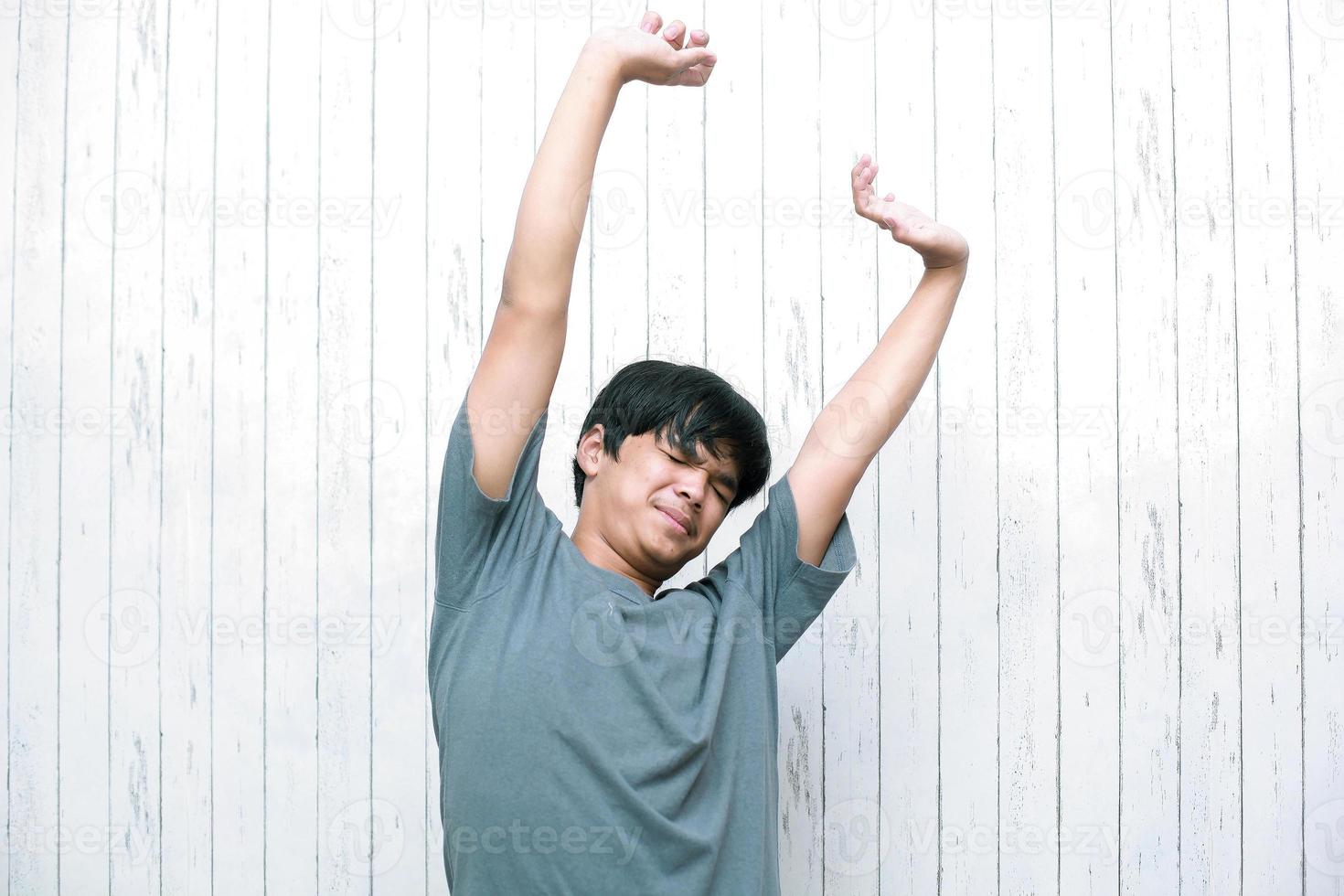 il giovane asiatico che allunga i muscoli delle braccia dopo il sonno e la lunga immobilità si sveglia. foto