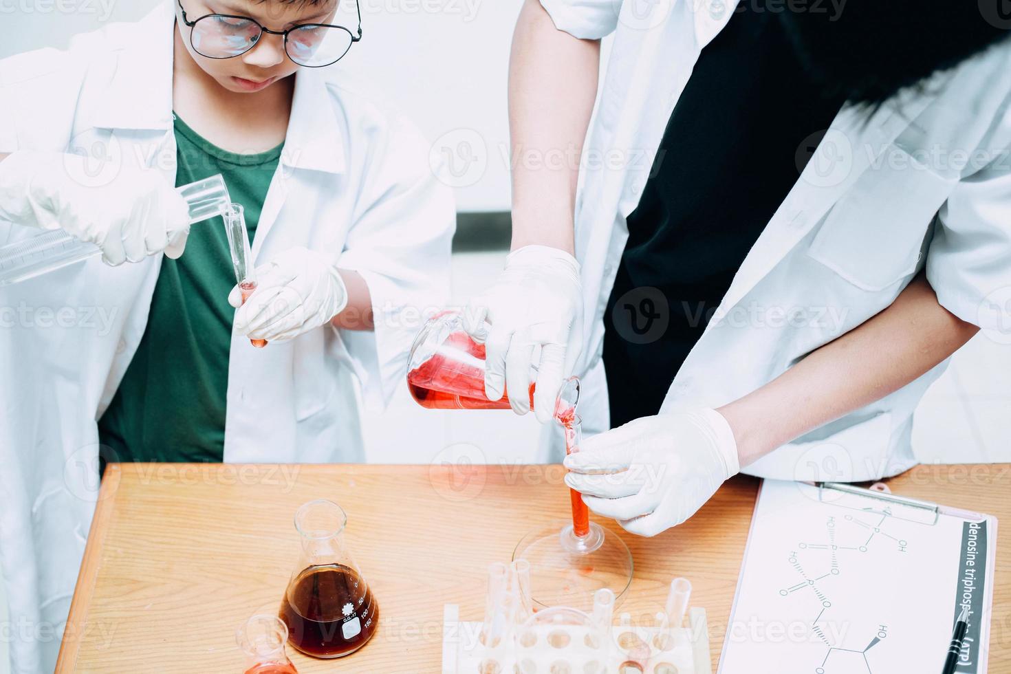 uno studente ragazzo che studia chimica con un insegnante in laboratorio. giornata nazionale della scienza, giornata mondiale della scienza foto