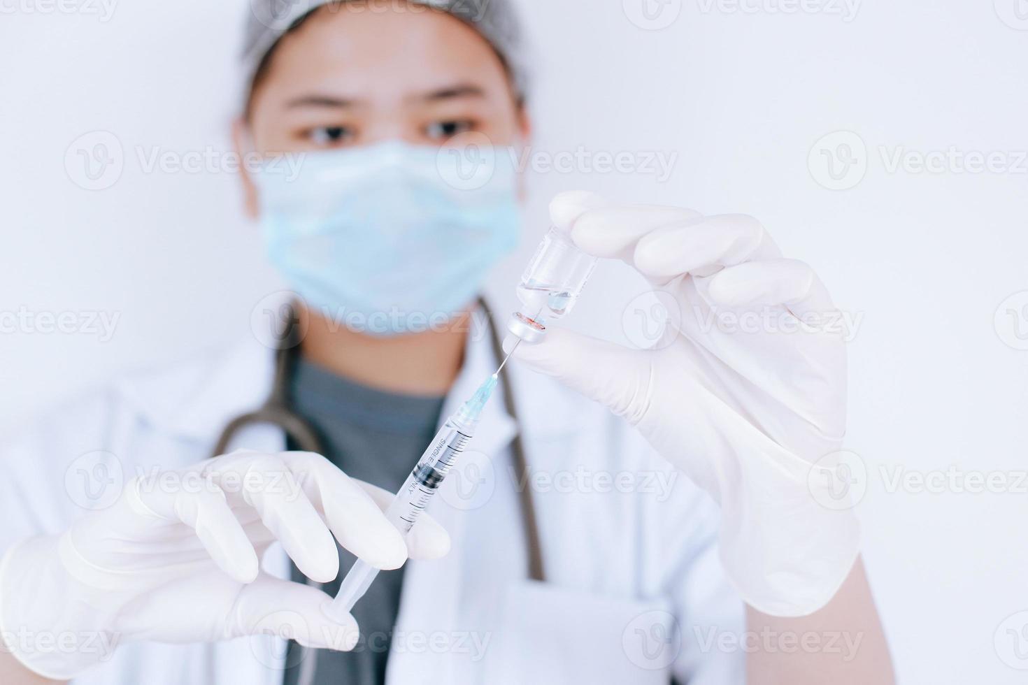 dottoressa o scienziata in laboratorio che tiene e riempie una siringa con vaccini liquidi, vaccinazione e immunizzazione. malattie concettuali, cure mediche, scienza. foto